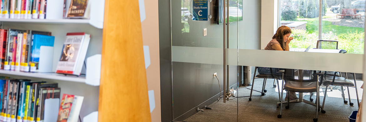 Woman using a study room with glass walls