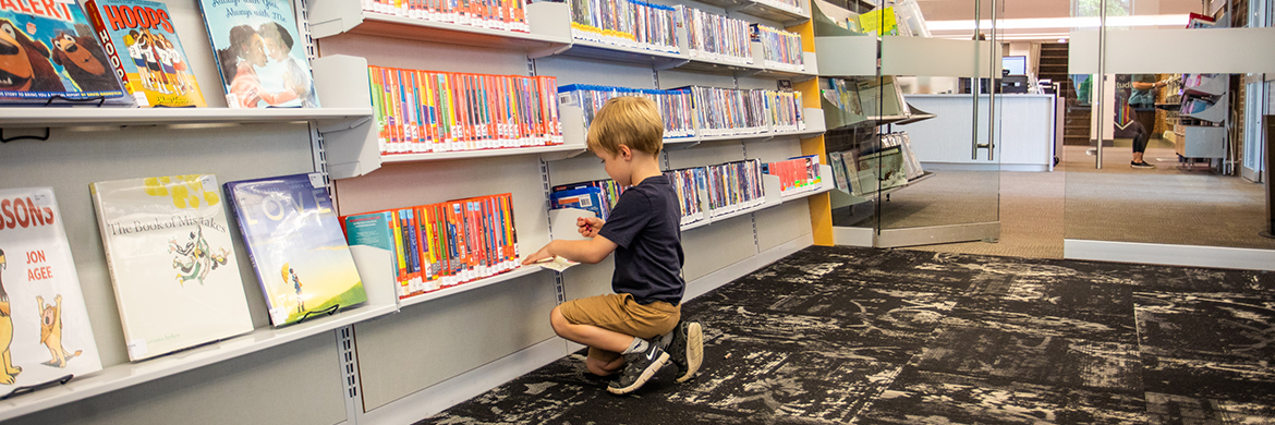 Young boy looking in the DVDs and Blu-Rays