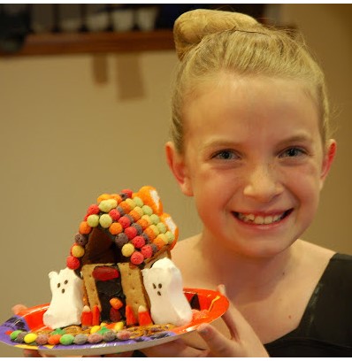 girl holding spooky candy house
