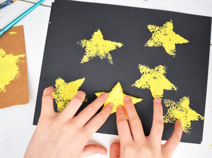 Kid using sponge to make star stamps