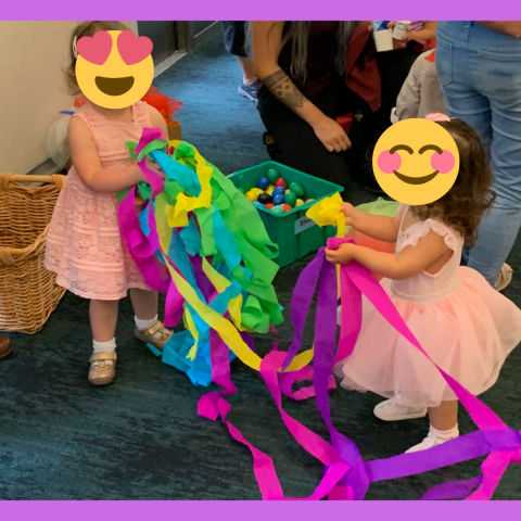 two babies in party dresses with streamers