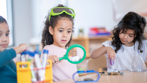 Child looking through a magnifying glass