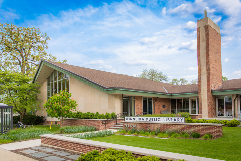 exterior picture of Winnetka-Northfield Public Library District, blue sky, some clouds, grass is green