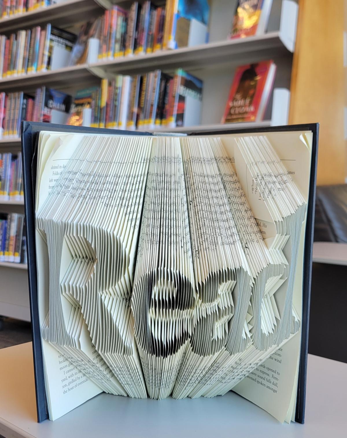 Book with pages folded to create illusion of the word "read"